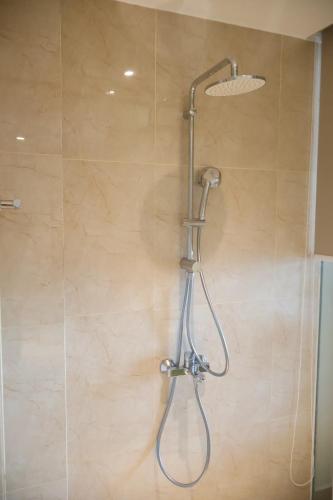 a shower with a shower head in a bathroom at Modern Beach Apartment - Arena Resort Cam Ranh in Cam Ranh International Airport