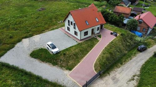 a house with a car parked in front of it at Pęglity jezioro in Gietrzwałd