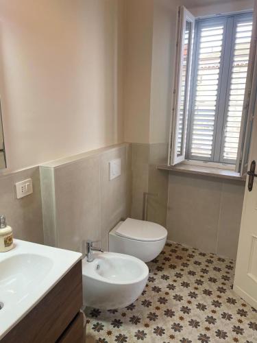 a bathroom with a white toilet and a sink at Camere al Borgo Affittacamere in Monteprandone