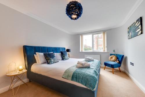 a bedroom with a large bed and a blue chair at Flat 1 Deco in Swanage