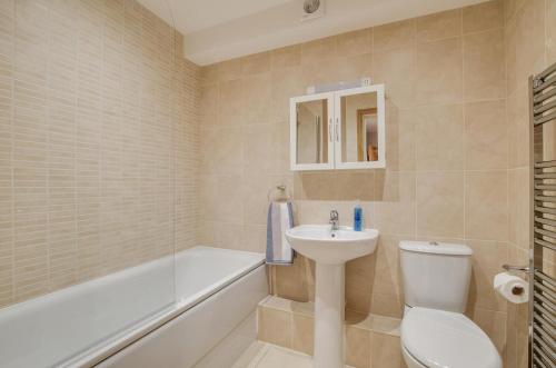a bathroom with a toilet and a sink and a bath tub at Flat 5 Penlu in Swanage