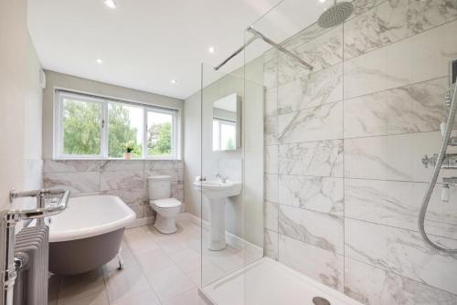 a bathroom with a tub and a sink and a toilet at Bobbin Cottage in Belper