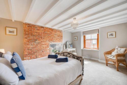 a bedroom with a bed and a brick wall at Bobbin Cottage in Belper