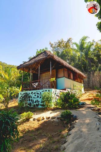 a small house with a thatched roof at Djema Forest in Nosy Be