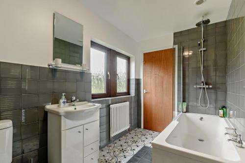 a bathroom with a tub and a sink and a bath tub at The Catlow in Parwich