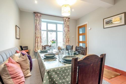 a dining room with a table and a couch at Hawkfield in Baslow