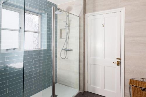 a bathroom with a shower with a glass door at Artists Coastal Retreat in Wool