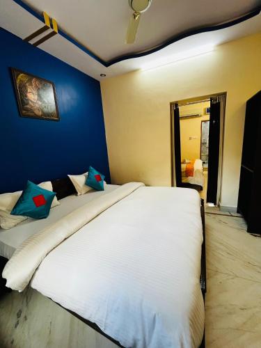 a bedroom with a large white bed with a blue wall at Golden Marigold Hotel in Jaisalmer