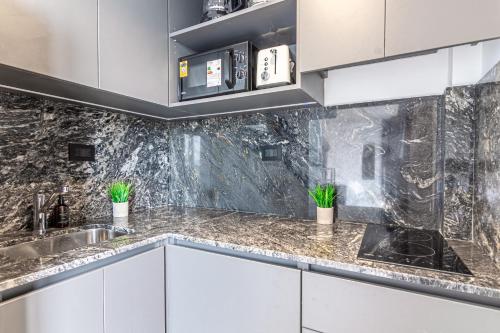 ブエノスアイレスにあるSoho Village Palermo Apartments - By Magnoのキッチン(白いキャビネット、大理石のカウンタートップ付)
