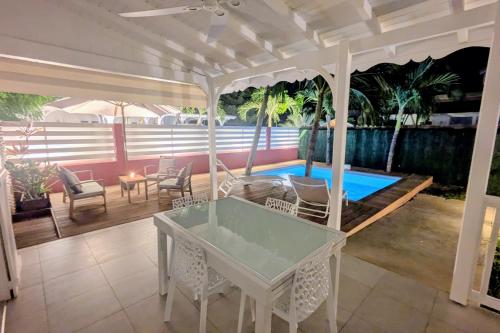a patio with a table and chairs and a swimming pool at Villa Saint-Martin "Guadeloupe" in Saint-François