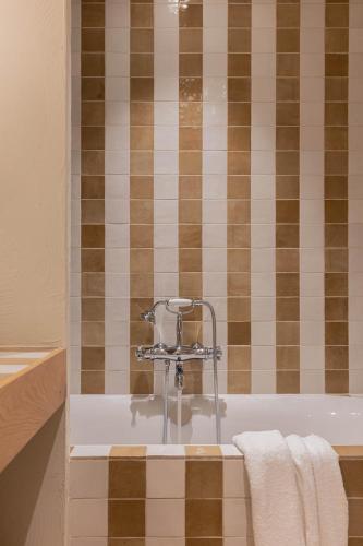 une baignoire avec un robinet dans une salle de bain dans l'établissement Hôtel Maison Chiberta, à Anglet