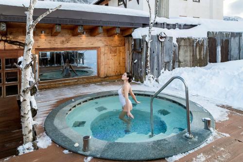 a man in a hot tub in the snow at La Torretta in Passo del Tonale