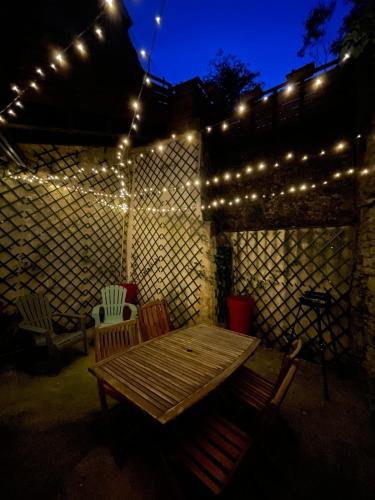 a patio with a wooden table and string lights at Au Cœur d Orgelet in Orgelet