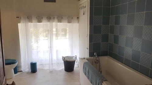 a bathroom with a tub and a window at Les Ecuries de Montdoucet in Souancé-au-Perche
