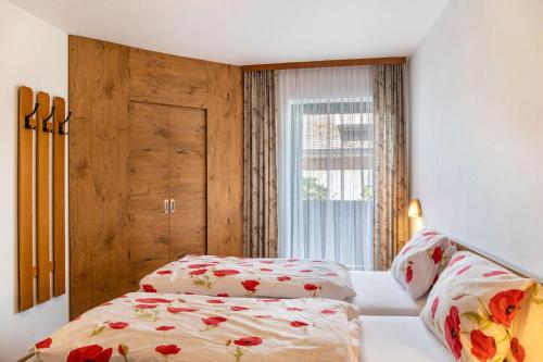 a bedroom with two beds and a window at Pension Heidelberg in Hopfgarten im Brixental