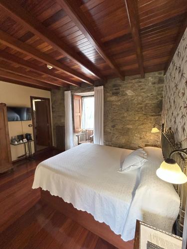 a bedroom with a large white bed in a room at Casa de Costoia in Santiago de Compostela