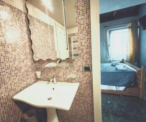 a bathroom with a sink and a room with a bed at Venice Dose Suite in Venice