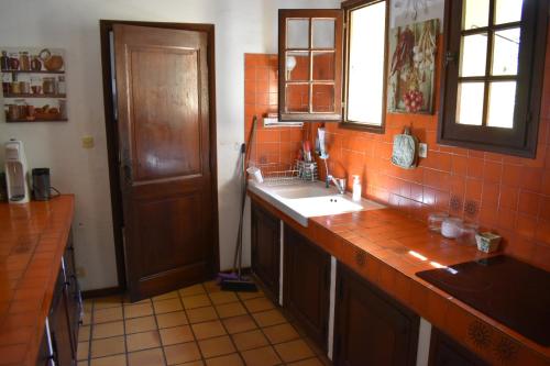 une cuisine avec un évier et une fenêtre et du carrelage orange dans l'établissement Maison familiale vue mer, à Grosseto-Prugna