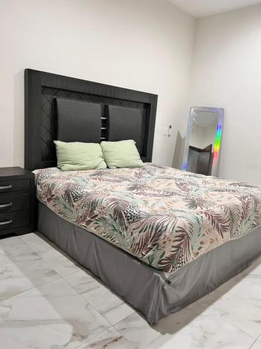 a bedroom with a large bed with a black headboard at Mazatlán Cervo vacacional in Mazatlán