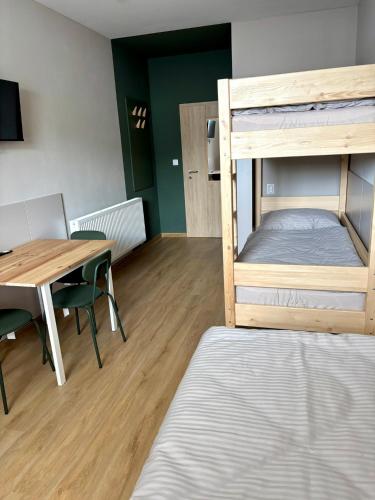 a room with a table and a bunk bed at el Gotel in Čadca
