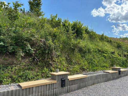 a row of benches on the side of a hill at el Gotel in Čadca