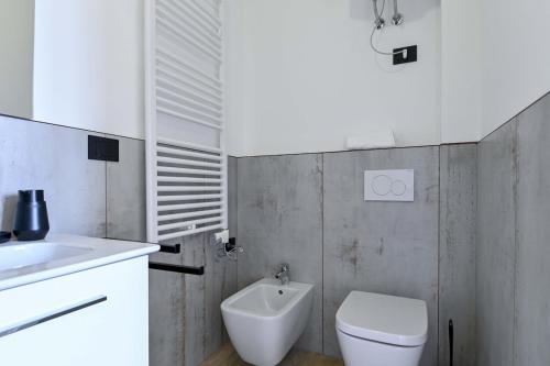 a white bathroom with a toilet and a sink at Villa Giovanna, Beautiful Rooms - by Host4U in Solto Collina
