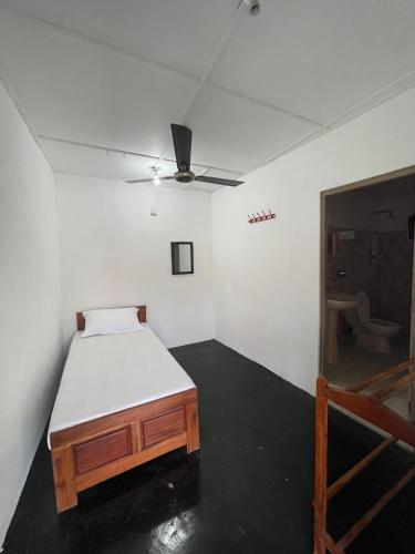 a bedroom with a bed and a ceiling fan at Anandas Beach Resort in Trincomalee
