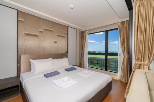 une chambre avec un lit et une grande fenêtre dans l'établissement Panora sea view -modern facilities walk to beach, à Surin Beach