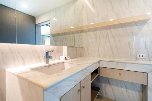 une salle de bains avec un lavabo et un miroir dans l'établissement Panora sea view -modern facilities walk to beach, à Surin Beach