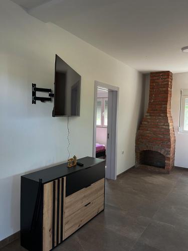 a living room with a flat screen tv and a fireplace at Casa Lisović in Lisović
