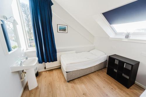 a small room with a bed and a sink at Broadford Backpackers Hostel in Broadford