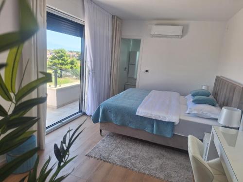 a bedroom with a bed and a large window at Villa Amphora in Vir