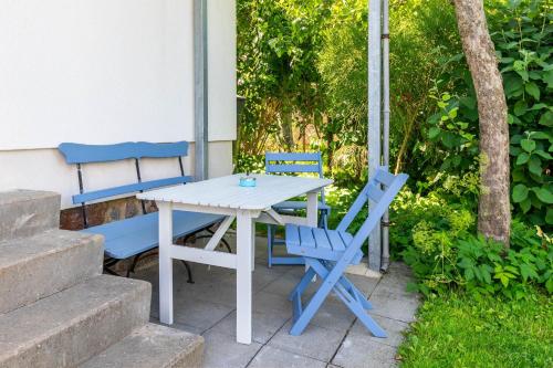 a white table and two blue chairs on a patio at Ferienhaus Andersson in Klütz