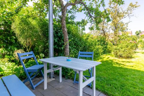 a white table and two blue chairs on a patio at Ferienhaus Andersson in Klütz