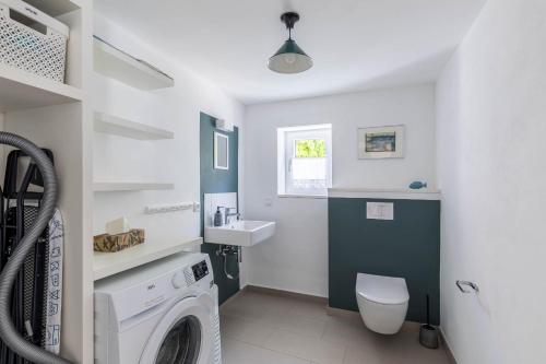 a bathroom with a washing machine and a sink at Ferienhaus Andersson in Klütz