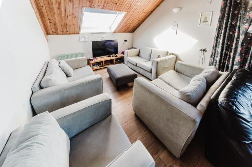 a living room with two couches and a tv at Broadford Backpackers Hostel in Broadford