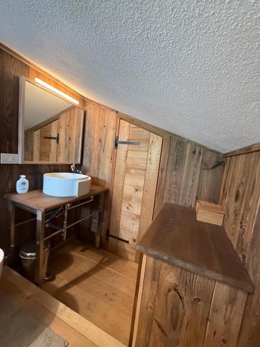 bagno con lavandino e parete in legno di Appartamento di montagna in puro stile chalet a Breuil-Cervinia