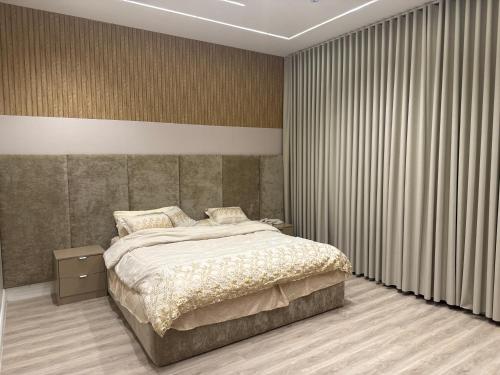 a bedroom with a large bed and curtains at المنزل الآمن in Medina