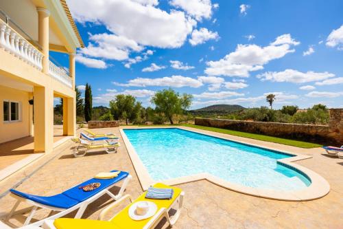 a villa with a swimming pool and a patio at Villa Entrecolinas in São Bartolomeu de Messines