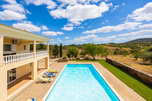 a villa with a swimming pool and a yard at Villa Entrecolinas in São Bartolomeu de Messines
