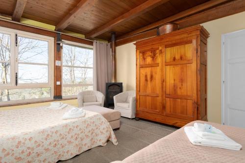 a bedroom with two beds and a wooden cabinet at Alpaca country house in Pontedera