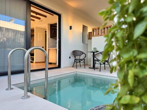 a swimming pool in a house with a table and chairs at Yucca Calma in Rhodes Town