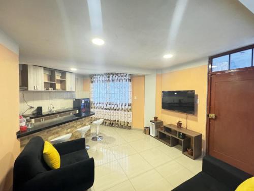 a living room with a couch and a television at Mini departamento en Cajamarca in Cajamarca