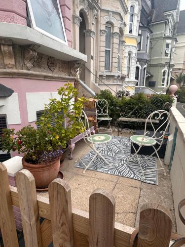 a patio with two chairs and a table on a balcony at La Di Da Hotel beach town in Bournemouth