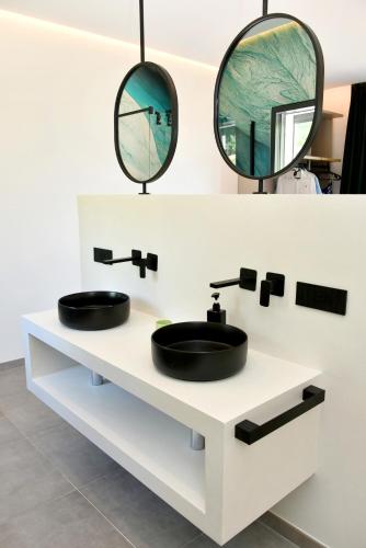 a bathroom with two sinks and two mirrors at Moddissi Charme in Trappola