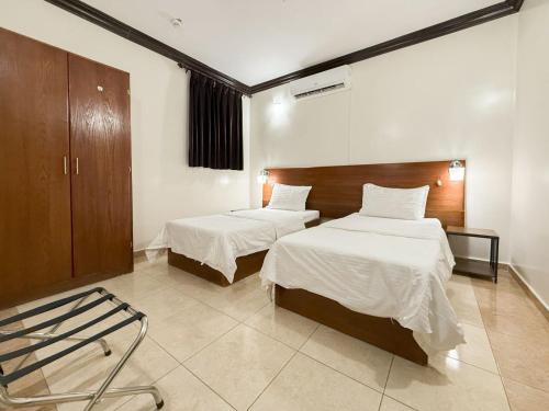 une chambre avec deux lits et une chaise dedans dans l'établissement شقق ليال الربيع Lial alrabe, à Az Zulfi