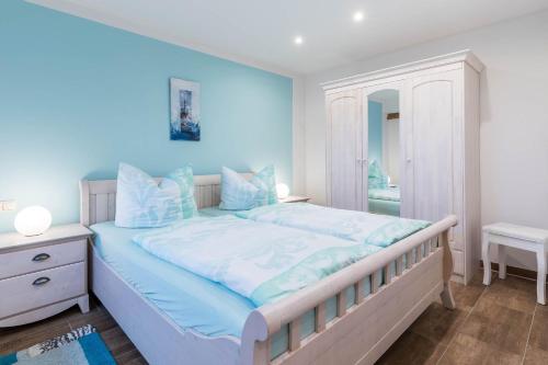 a bedroom with a large bed with blue walls at Ferienwohnung Tilda in Redewisch