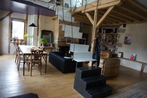 un salon avec une table et une salle à manger dans l'établissement l'entresort, à Aubusson
