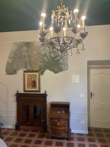 a chandelier hanging from a wall with a wooden table at Camere al Borgo Affittacamere in Monteprandone