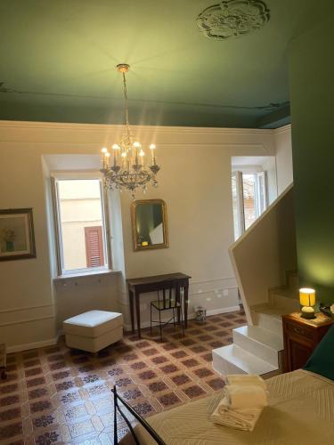 a room with a chandelier and stairs in a house at Camere al Borgo Affittacamere in Monteprandone